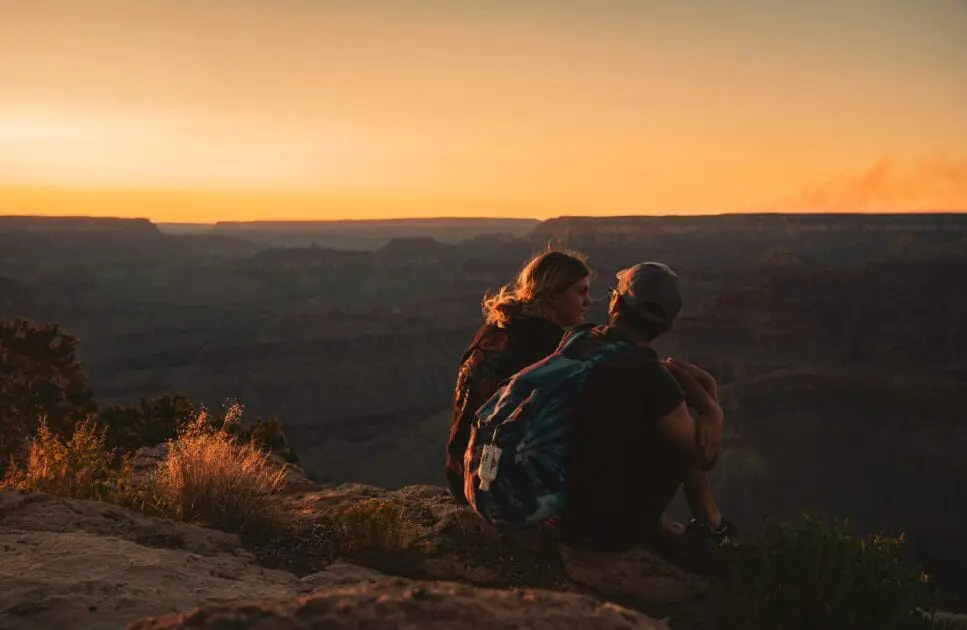 Man and woman sitting on a mountain edge. Hypnotherapy near Northgate. Brisbane Livewell Clinic