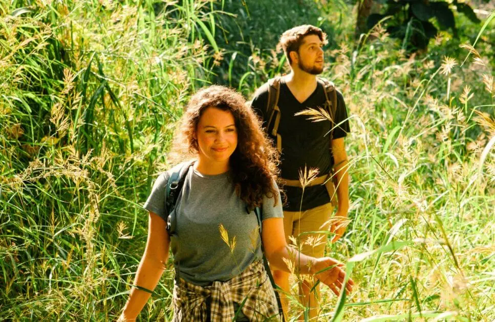 Man and woman walking trough a through a field of tall grass. Leaky Gut Syndrome. Osteopath Morningside. Osteopath for Shoulder Pain. Brisbane Livewell Clinic