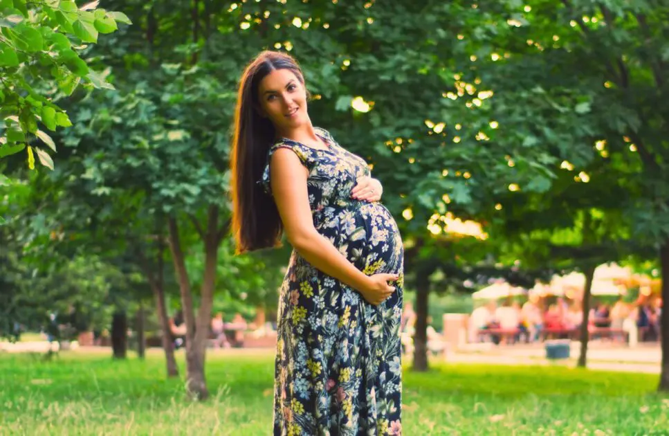 Pregnant woman standing in the park. Pregnancy Massage Near Me. Prenatal Naturopath. Is Osteopathy Safe during Pregnancy. Brisbane Livewell Clinic