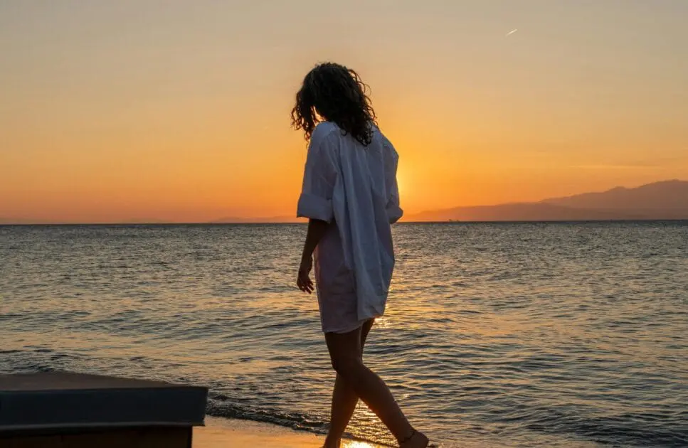 Woman strolling along the beach as the sun sets. Test Cortisol at Home. Brisbane Livewell Clinic