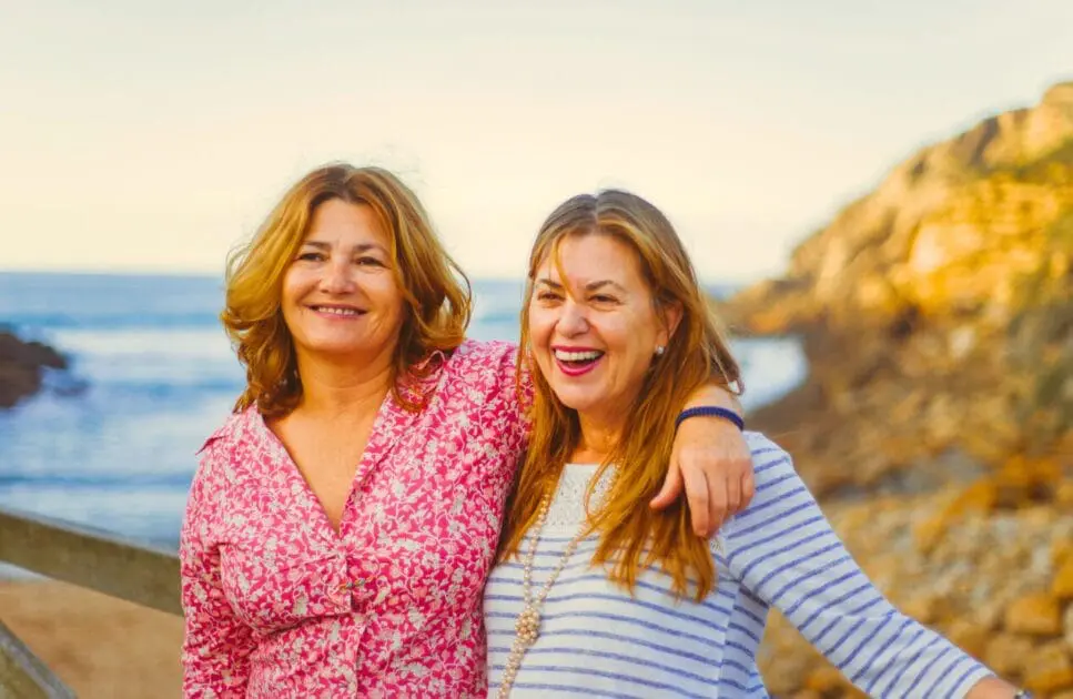 Two women standing on a wooden bridge. Victims Services Counselling. Menopause. Osteopath Support Lower Back Discomfort. Brisbane Livewell Clinic