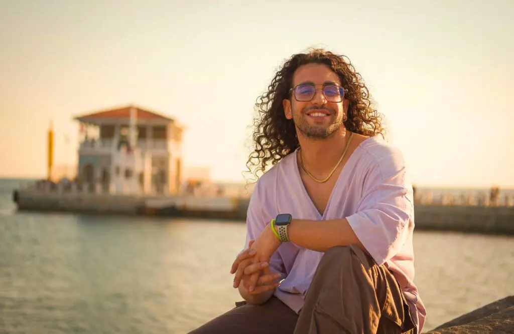 Smiling man sits on the seaside. What is Bowen Treatment. Addiction Hypnotherapy. Bowen Therapy Cost. Hypnosis to Stop Smoking. Brisbane Livewell Clinic