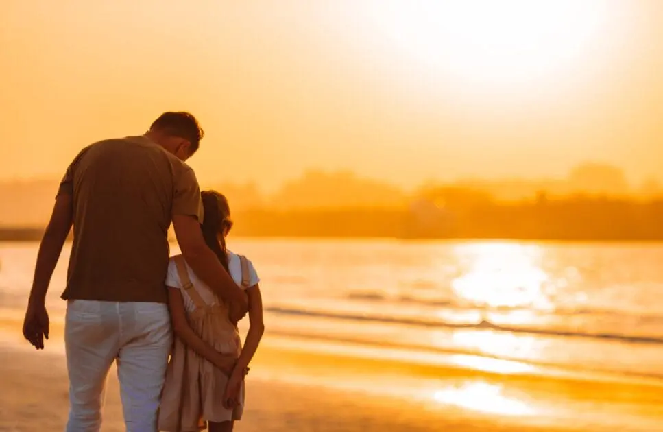 Father and daughter walking along the beach during sunset. Hypnotherapy near Chermside West. Brisbane Livewell Clinic