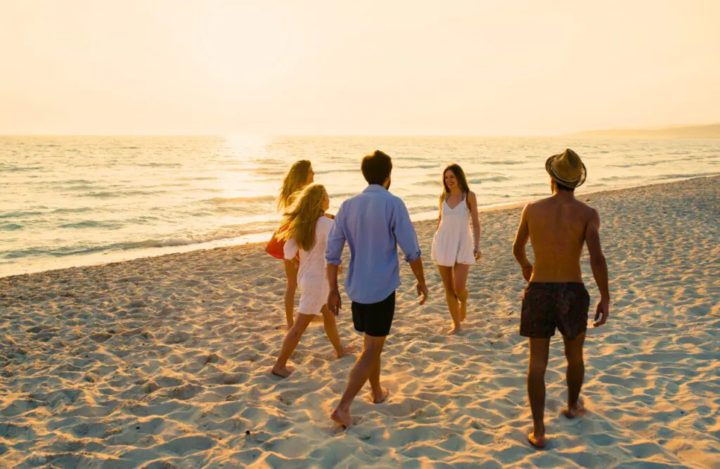 Friends walking together at the beach. How to Get Hormone Levels Checked. What does an Osteopath do. Brisbane Livewell Clinic