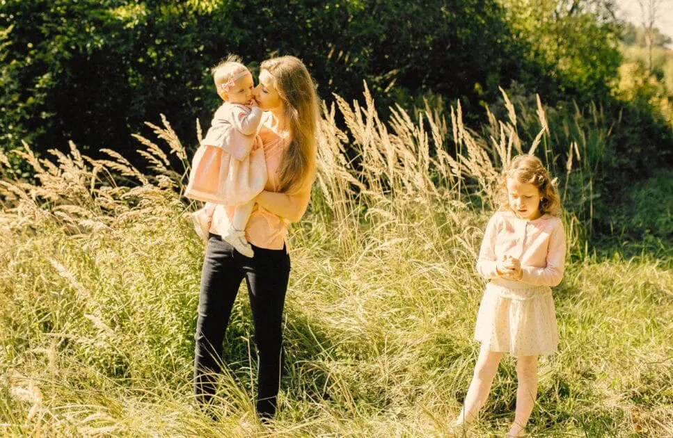 Mother and her children walking in a field on a sunny day. Hypnotherapy near Chermside. Childrens Naturopath. Brisbane Livewell Clinic