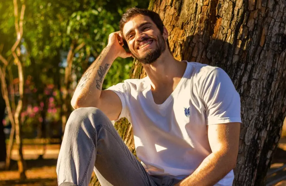 Smiling man resting near tree trunk. Holistic Counselling. 6 Chinese Medicine Treatments. Naturopathic Practitioner. Osteopath Support Lower Back Discomfort. Lose Weight Hypnotherapy. Brisbane Livewell Clinic