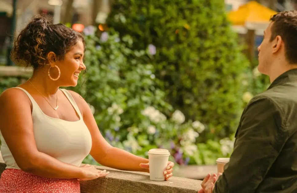 Man and woman sitting on a bench, drinking takeaway coffee. Drug and Alcohol Counselling. What is Holistic Counselling. Lose Weight Hypnotherapy. Brisbane Livewell Clinic