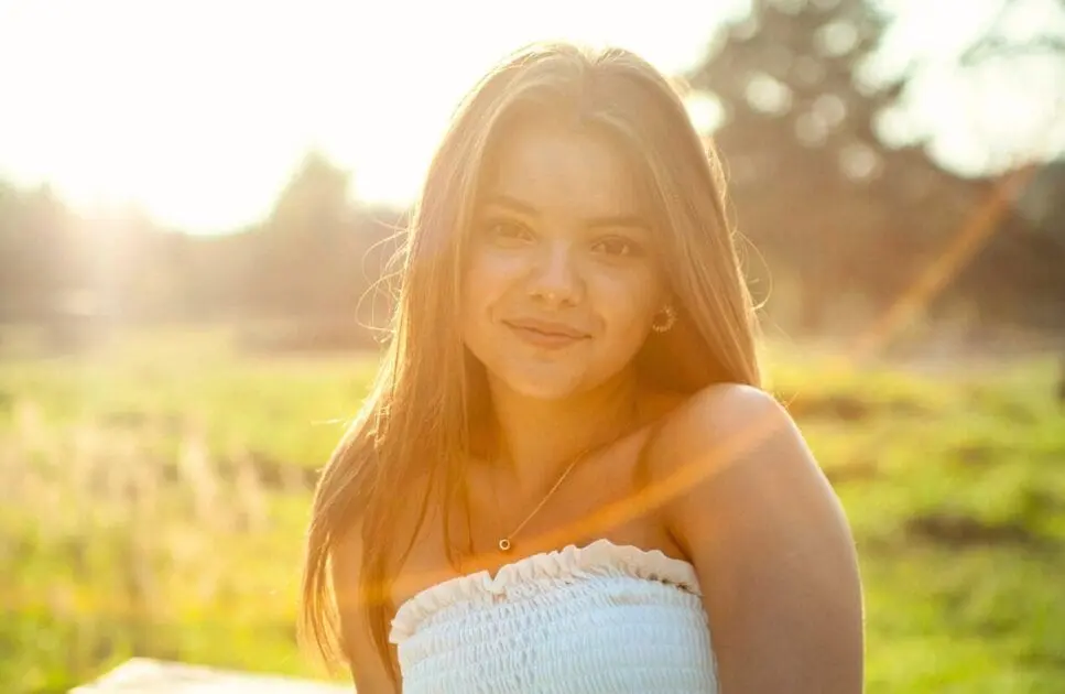 Portrait of a smiling woman sitting on a bench outdoors. Hypnotherapy near Nundah. Holistic Counselling Near Me. Brisbane Livewell Clinic