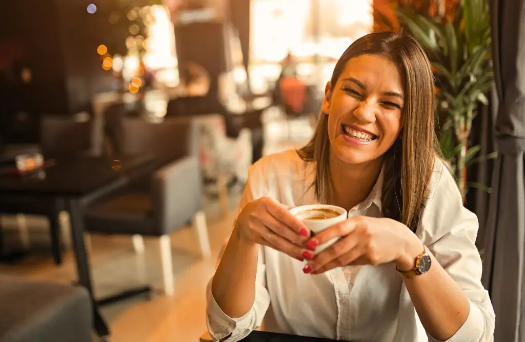 Woman enjoying her coffee at a cafe. Brisbane Wellbeing. Osteopathy for Shoulder Pain and Restriction. How often should you see an Osteopath. Brisbane Livewell Clinic