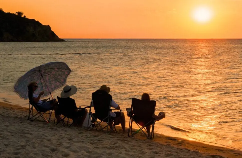 Group of friends sitting near the beach, watching sunset. Cortisol Test Australia. Brisbane Livewell Clinic