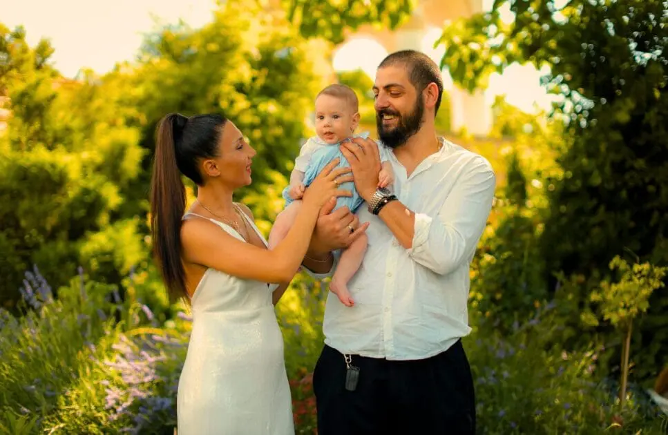 Man and woman carrying their baby in a garden, surrounded by flowers and trees. Drug and Alcohol Counselling. Can Irritable Bowel Syndrome cause weight gain. SIBO Test Brisbane. Infant colic. Brisbane Livewell Clinic