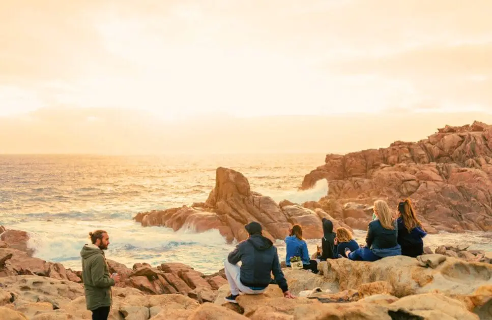 People sitting on rocks near the ocean waiting for the sunset. Hypnotherapy near Wooloowin. Brisbane Livewell Clinic