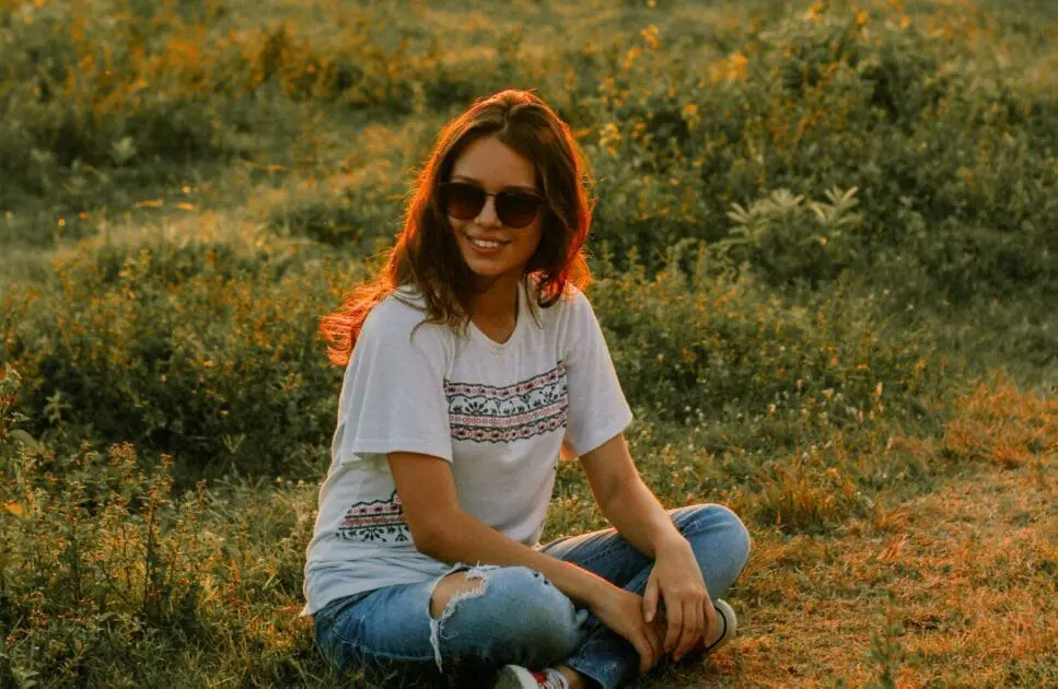 Woman sitting on a grass field looking at the sunset. Hypnotherapy near Wooloowin. Gut Health Test Australia. Healing Power of Bowen Massage Therapy. I Feel Too Much Too Deeply. Brisbane Livewell Clinic