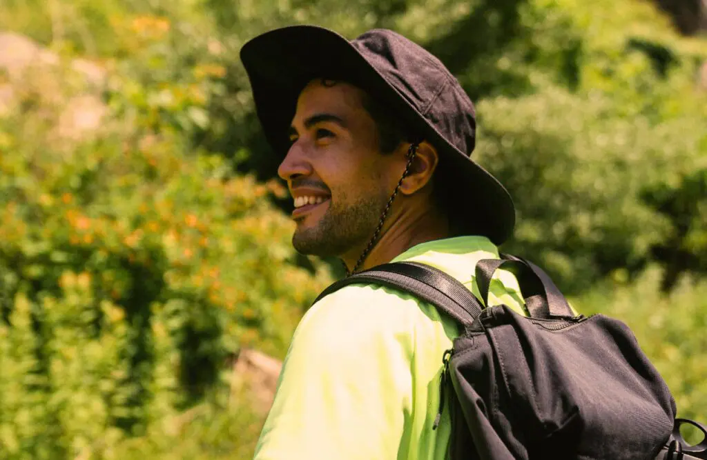 Man in a hat and backpack standing outdoors, ready for an adventure. Leaky Gut Syndrome. Hypnotherapy for Alcohol Addiction. How Osteopathy may Support Injury Recovery and Mobility. Brisbane Livewell Clinic
