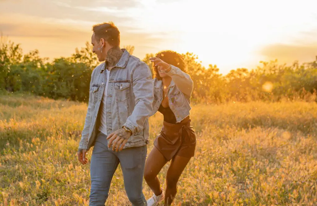 Couple laughing and walking together in a field. Hypnotherapy for Alcohol Addiction. Brisbane Livewell Clinic