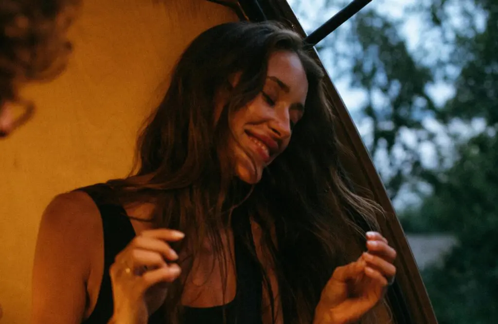 Smiling woman sitting on the car trunk. Migraine. Naturopath Redcliffe. Food Intolerance Testing Brisbane. Brisbane Livewell Clinic