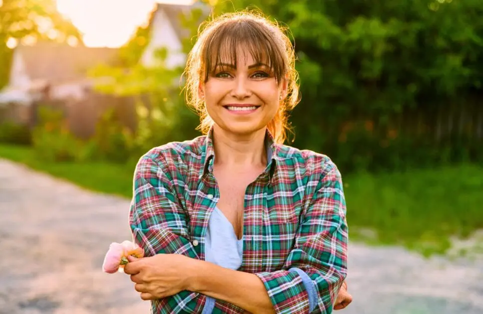 Smiling woman holding flowers outdoors. Naturopath Women's Health. Naturopath Brisbane. Heavy Metal Detox Naturopath. Brisbane Livewell Clinic