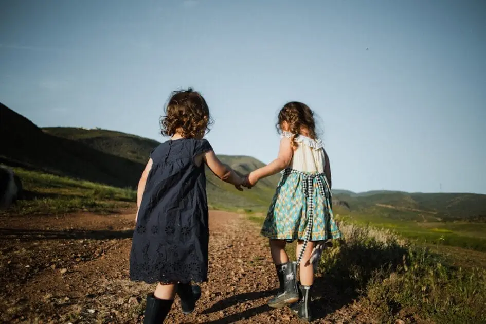 2 girls in blue dresses climbing a bill. Children's Naturopath. Childrens Naturopath
